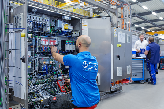 Elektroniker von blue automation arbeitet an einem Schaltschrank