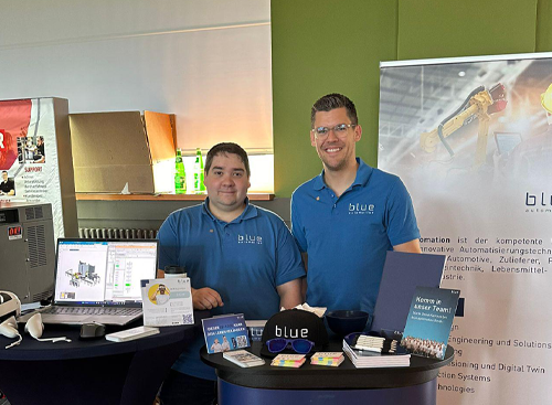 Two people from blue automation stand smiling at a trade fair stand